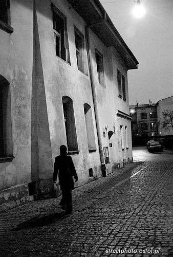 Dzielnica Kazimierz. Kobieta idąca brukowaną uliczką, Postać na ulicy