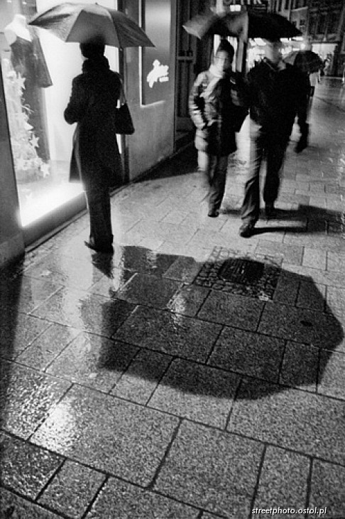 Kobieta z parasolką, Kraków, Grodzka, witryna sklepowa, miasto nocą.